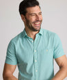 Model is wearing UNTUCKit Forbes performance seersucker short sleeve shirt in green. 