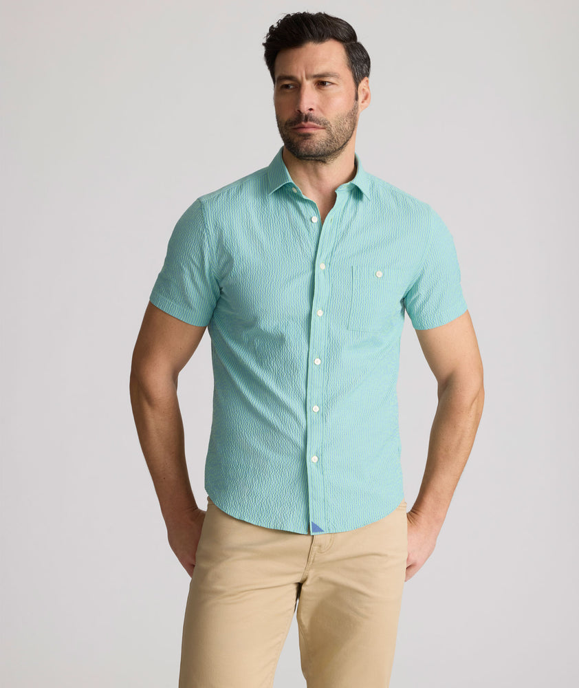Model is wearing UNTUCKit Forbes performance seersucker short sleeve shirt in green. 