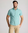 Model is wearing UNTUCKit Forbes performance seersucker short sleeve shirt in green. 