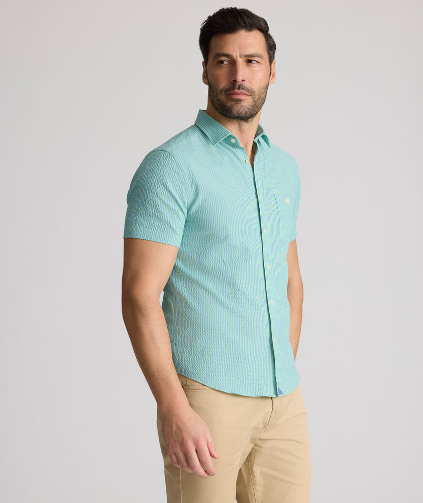 Model is wearing UNTUCKit Forbes performance seersucker short sleeve shirt in green. 