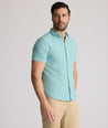 Model is wearing UNTUCKit Forbes performance seersucker short sleeve shirt in green. 
