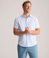 Model is wearing UNTUCKit Forbes performance seersucker short sleeve shirt in cerulean. 