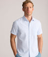 Model is wearing UNTUCKit Forbes performance seersucker short sleeve shirt in cerulean. 