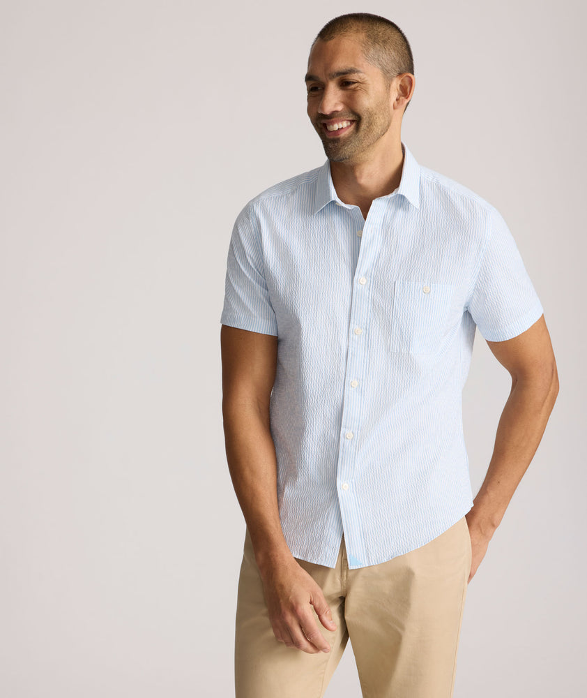 Model is wearing UNTUCKit Forbes performance seersucker short sleeve shirt in cerulean. 