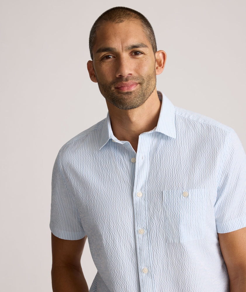 Model is wearing UNTUCKit Forbes performance seersucker short sleeve shirt in cerulean. 