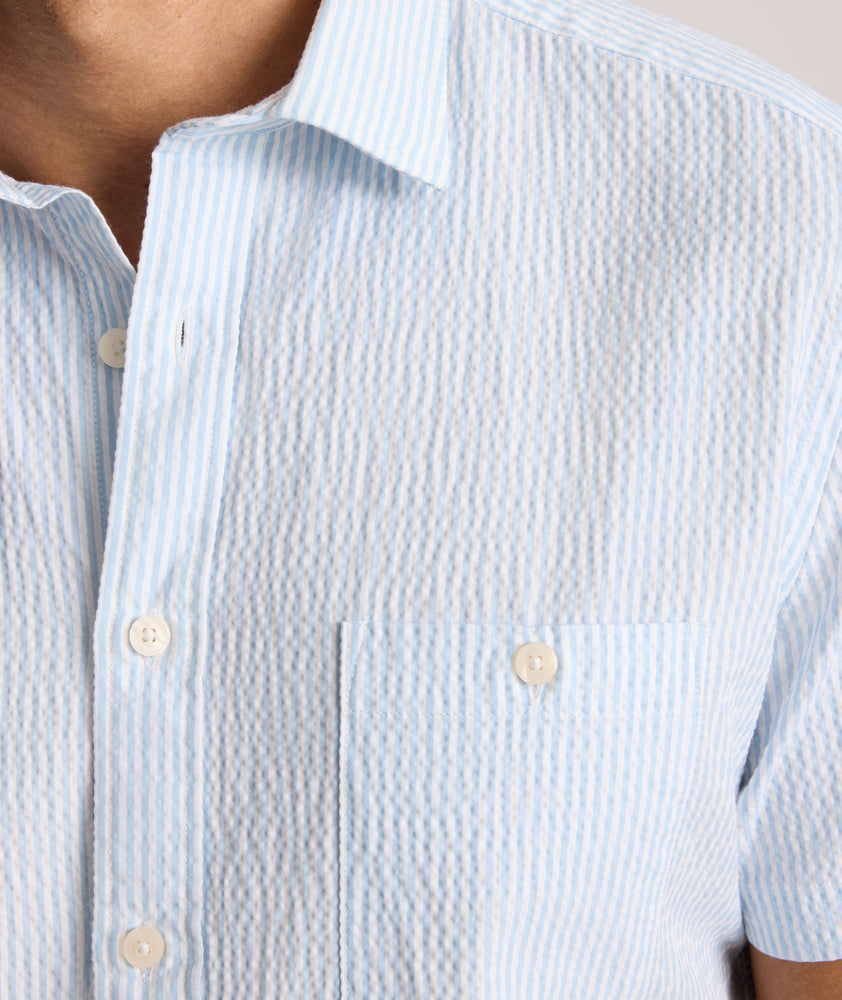 Model is wearing UNTUCKit Forbes performance seersucker short sleeve shirt in cerulean. 