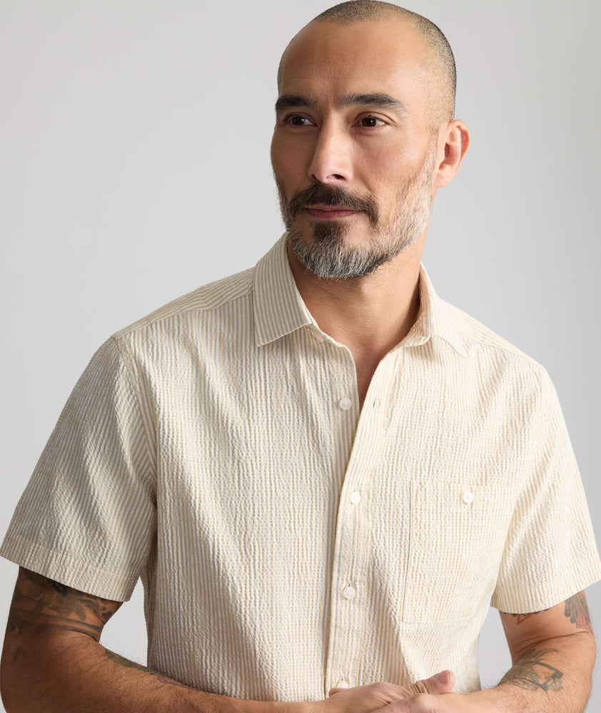 Model is wearing UNTUCKit Performance Seersucker Short-Sleeve Shirt in tan. 
