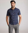 Model is wearing UNTUCKit Freeman performance short sleeve shirt in navy with orange floral shirt. 