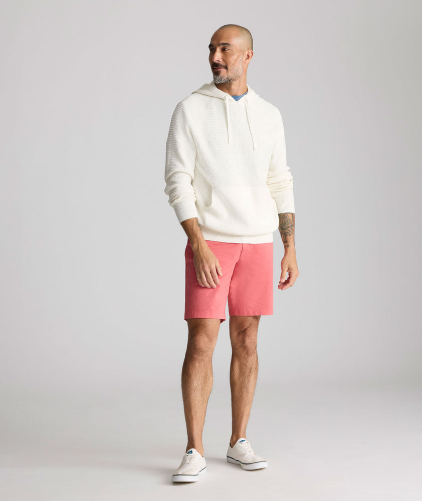 Model is wearing UNTUCKit 9" Stretch Chino Shorts in red. 