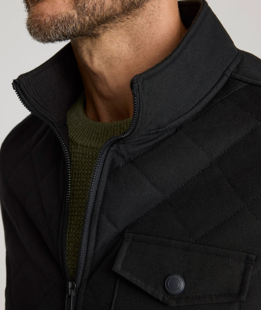 Model is wearing UNTUCKit Gardner jacket in black beauty. 