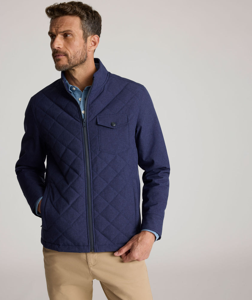 Model is wearing UNTUCKit Gardner quilted jacket in patriot blue.
