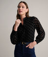 Model is wearing UNTUCKit Gemma shirt in black polka dot. 