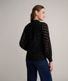 Model is wearing UNTUCKit Gemma shirt in black polka dot. 