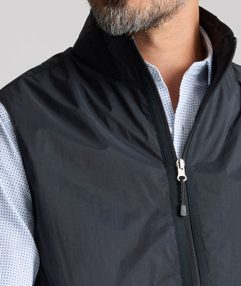 Model is wearing UNTUCKit Performance Packable Vest in black. 