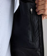 Model is wearing UNTUCKit Performance Packable Vest in black. 