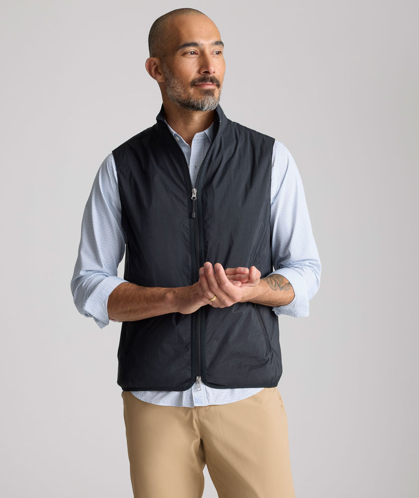 Model is wearing UNTUCKit Performance Packable Vest in black. 