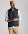 Model is wearing UNTUCKit Performance Packable Vest in black. 