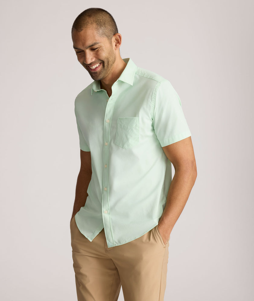 Model is wearing UNTUCKit Gironde short sleeve performance  shirt in bright green. 
