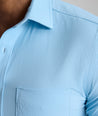 Model is wearing UNTUCKit Performance Gironde Shirt in light blue. 