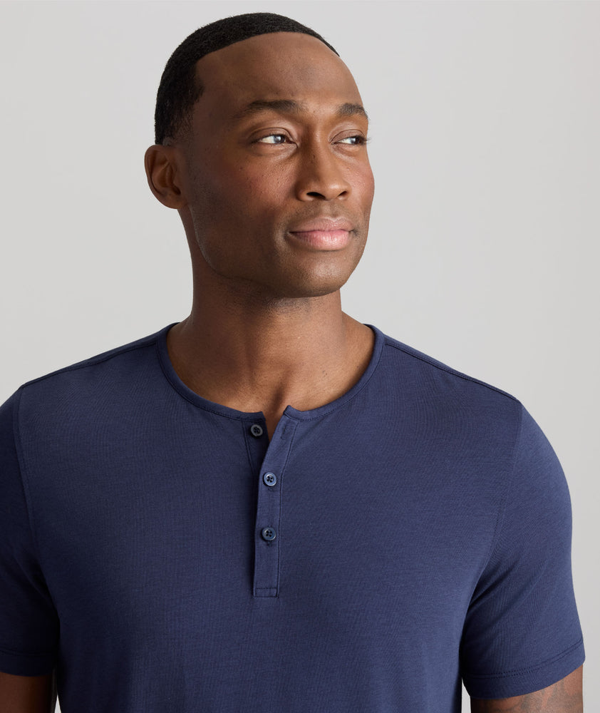 Model is wearing UNTUCKit glera henley in peacoat.