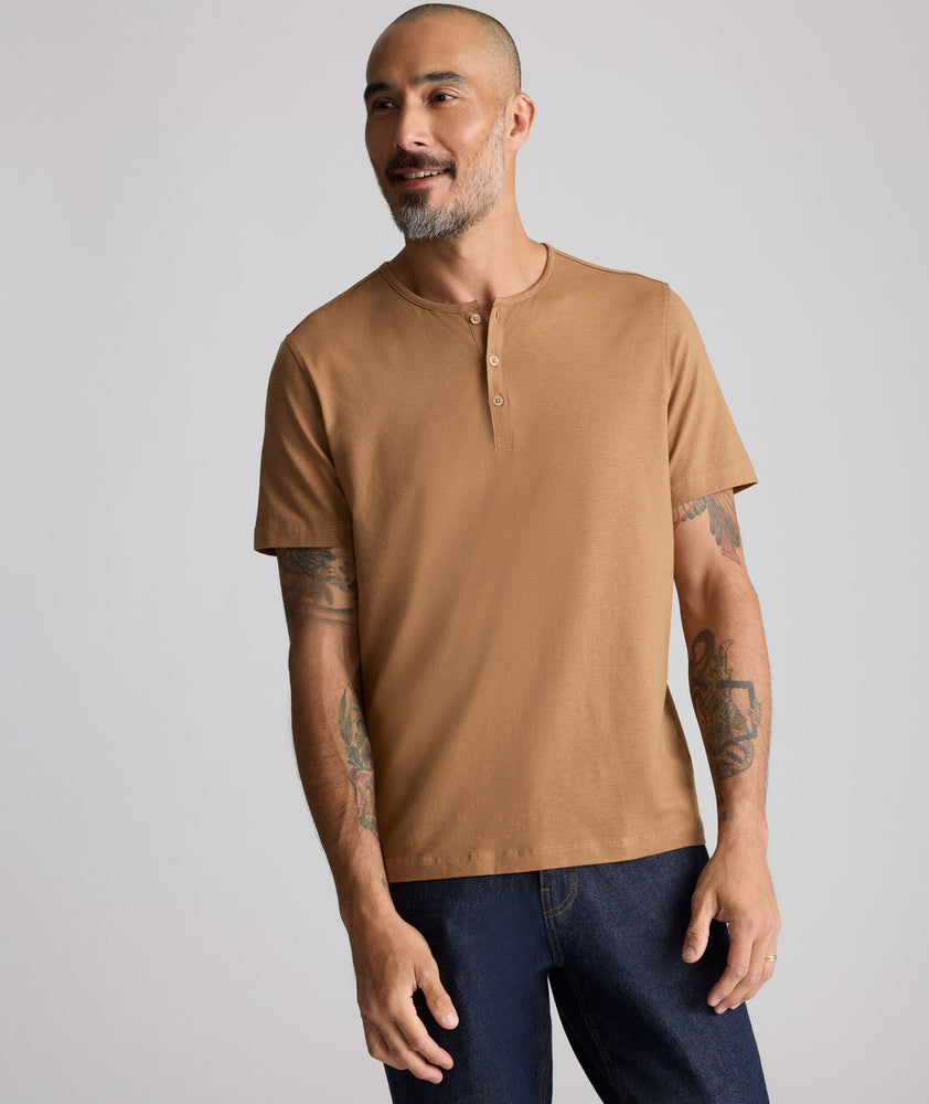 Model is wearing UNTUCKit EcoSoft Short-Sleeve Henley in toasted coconut. 