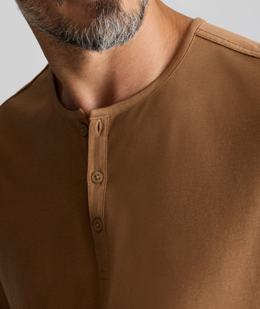Model is wearing UNTUCKit EcoSoft Short-Sleeve Henley in toasted coconut. 