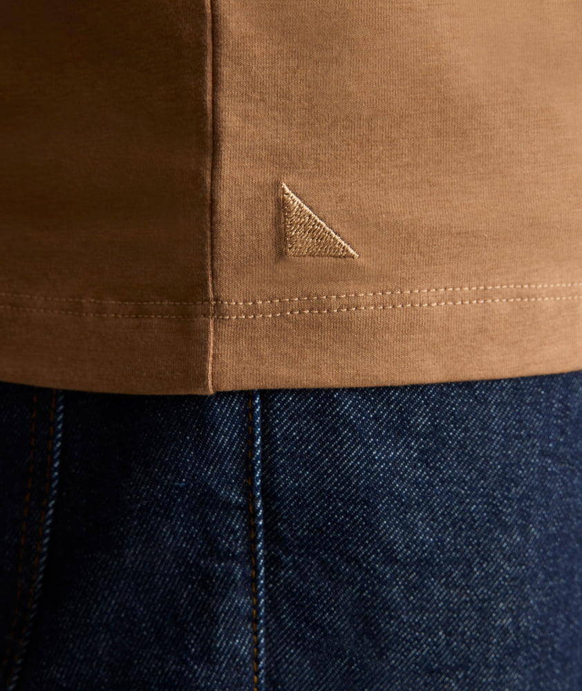 Model is wearing UNTUCKit EcoSoft Short-Sleeve Henley in toasted coconut. 