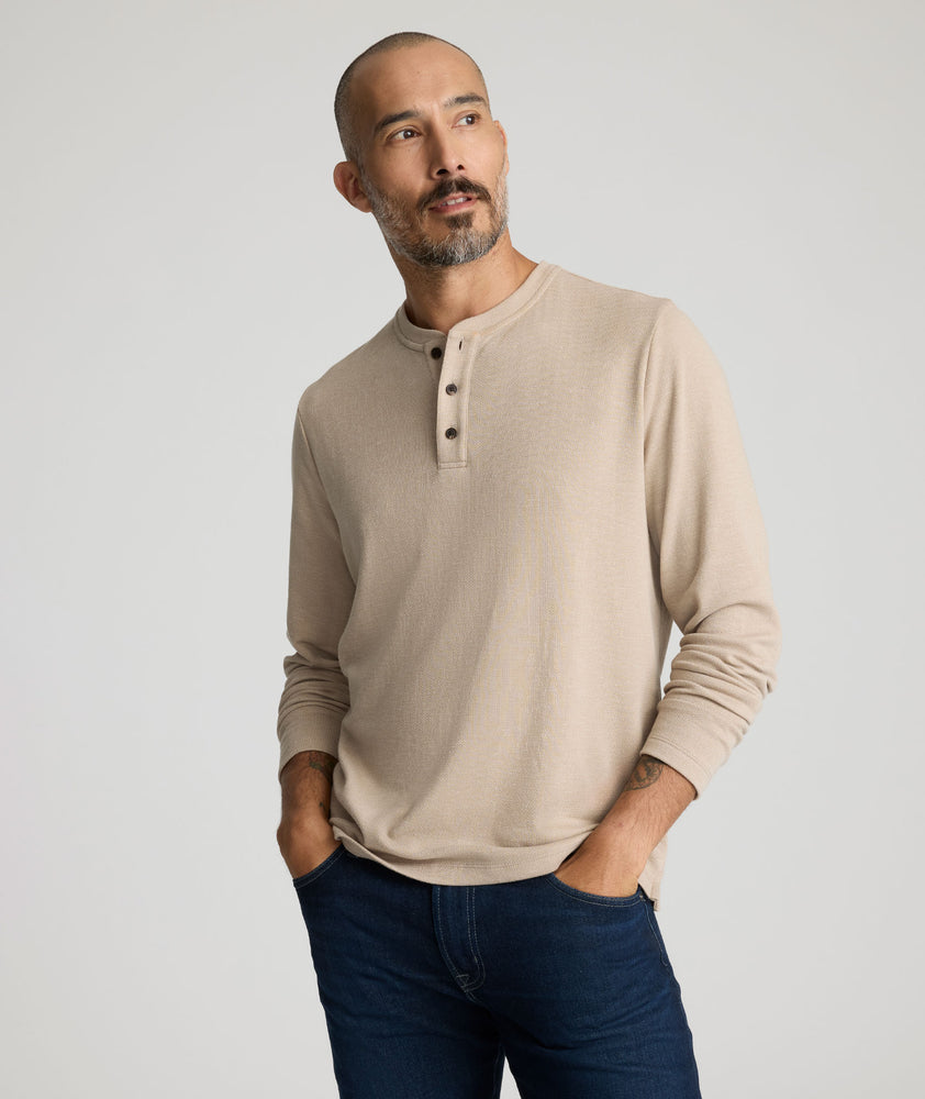 Model is wearing UNTUCKit Harrow henley in cobblestone. 