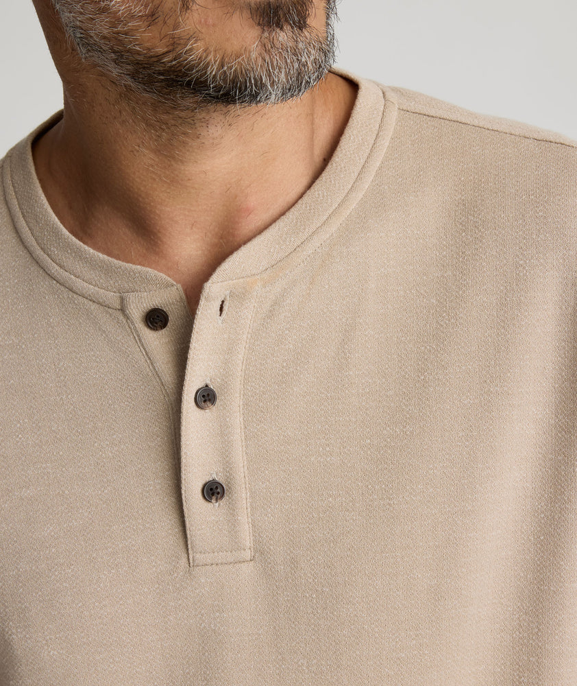 Model is wearing UNTUCKit Harrow henley in cobblestone. 
