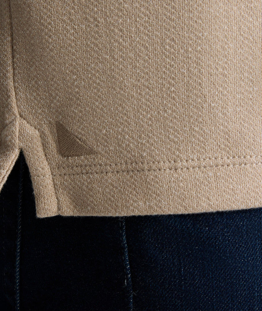 Model is wearing UNTUCKit Harrow henley in cobblestone. 