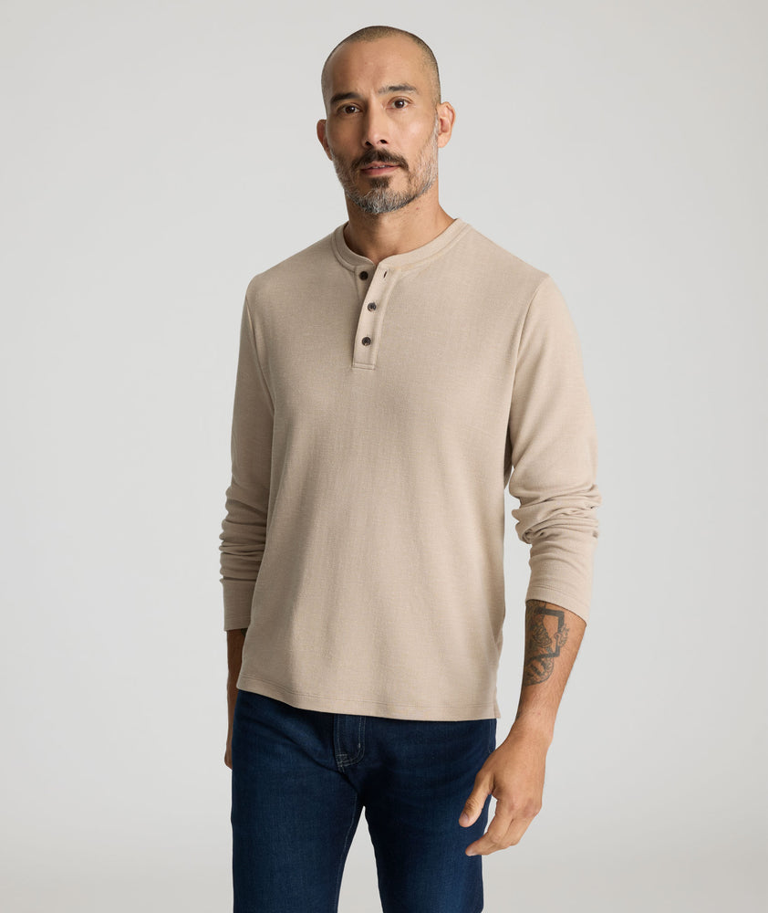 Model is wearing UNTUCKit Harrow henley in cobblestone. 