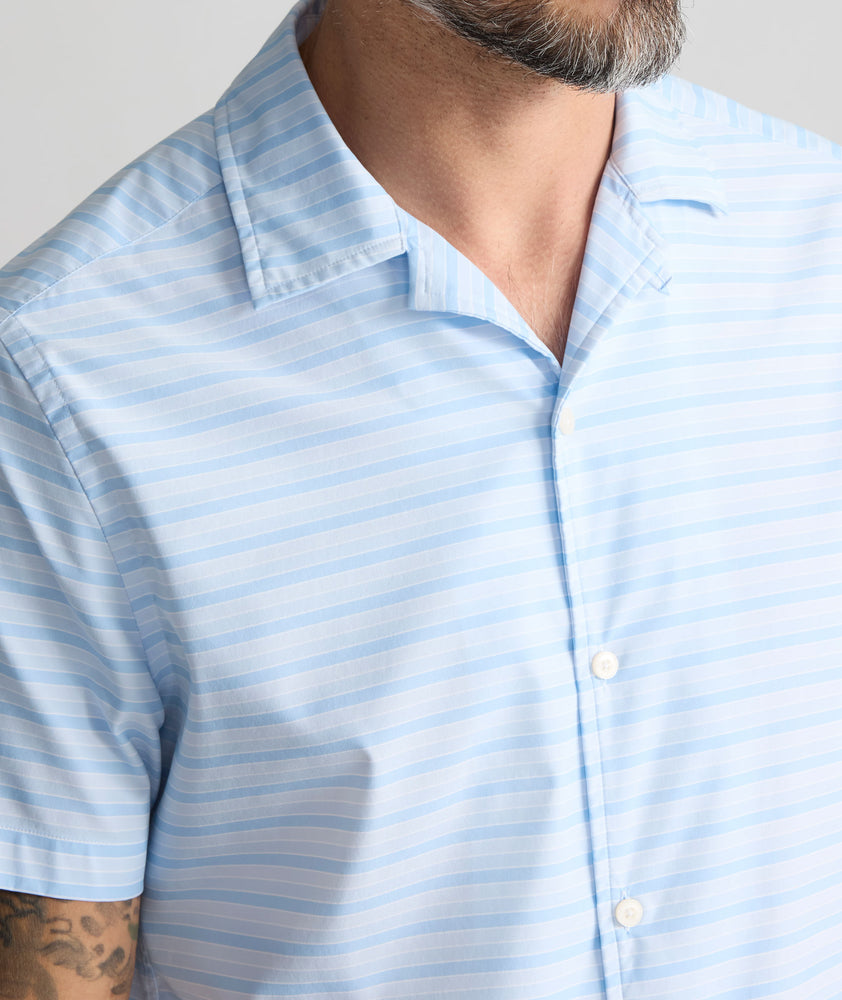 Model is wearing UNTUCKit Performance Short-Sleeve Camp Collar Shirt in blue stripe. 