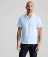 Model is wearing UNTUCKit Performance Short-Sleeve Camp Collar Shirt in blue stripe. 