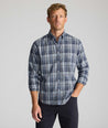 Model is wearing UNTUCKit Wrinkle-Free Hearthstead Shirt in blue and navy check. 