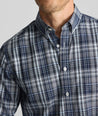 Model is wearing UNTUCKit Wrinkle-Free Hearthstead Shirt in blue and navy check. 