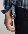 Model is wearing UNTUCKit Wrinkle-Free Hearthstead Shirt in blue and navy check. 