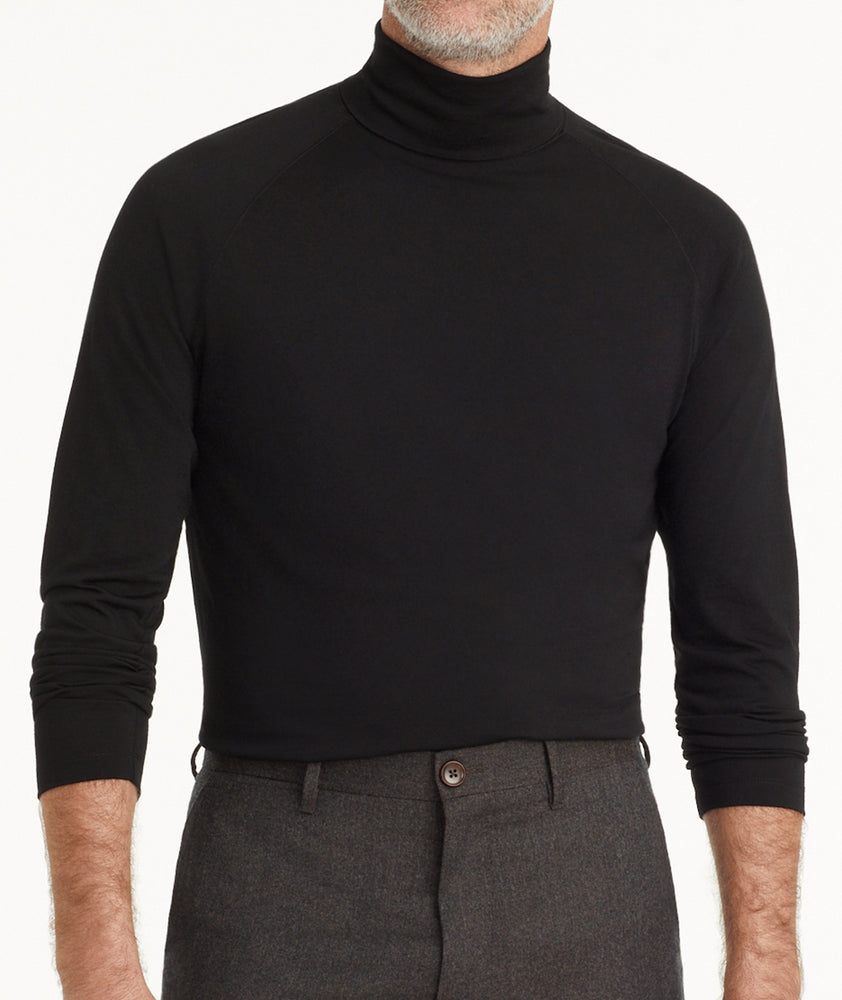 Model is wearing UNTUCKit Hilburn turtleneck in black. 