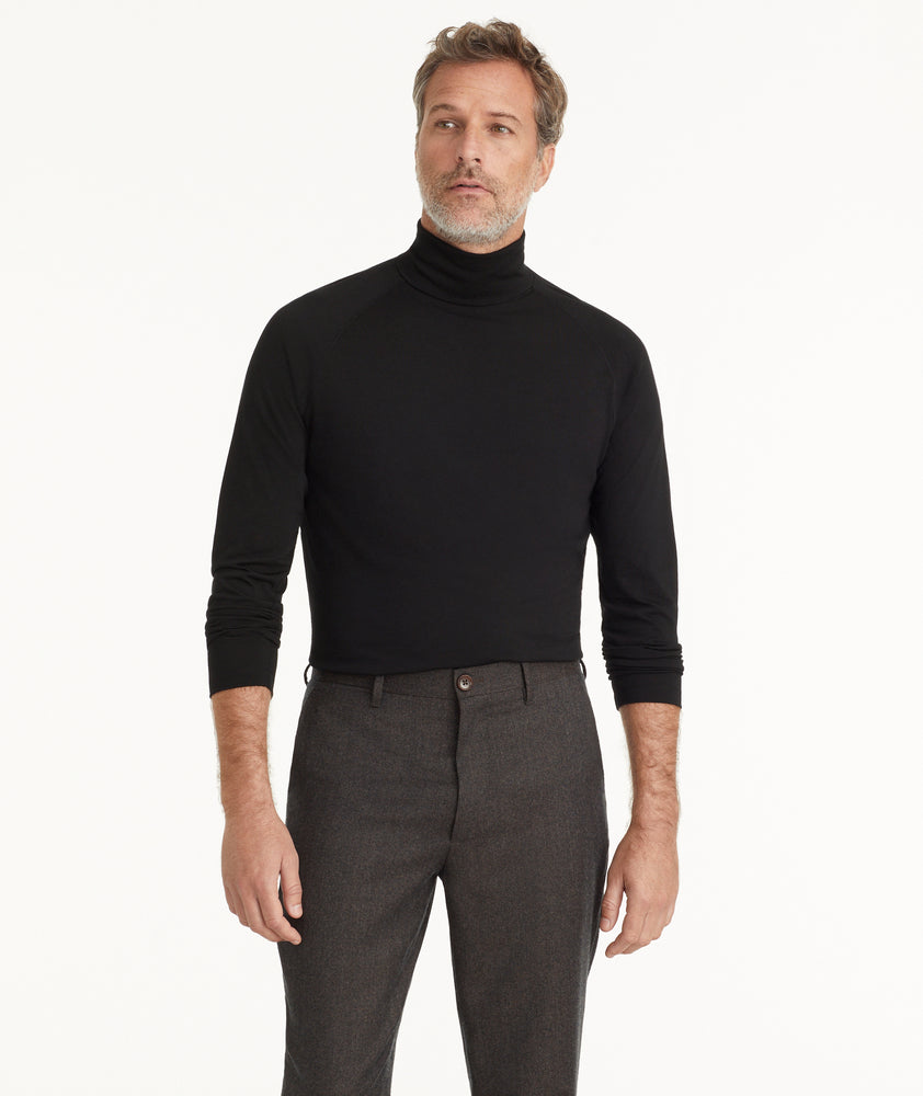 Model is wearing UNTUCKit Hilburn turtleneck in black.