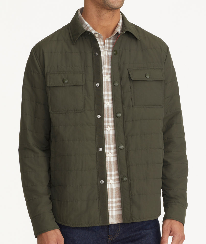 Model is wearing UNTUCKit Holderson jacket in forest. 