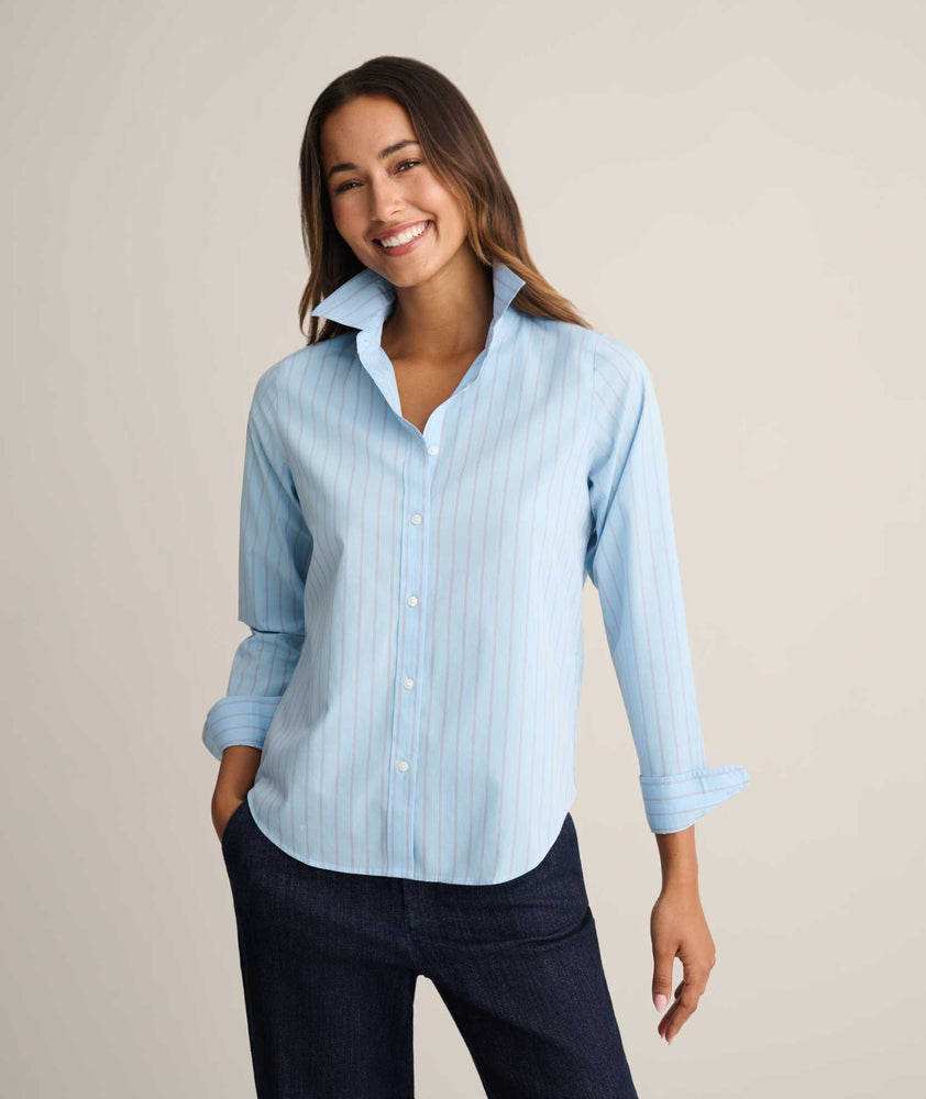 Model is wearing UNTUCKit Isabella shirt in blue and pink stripe. 