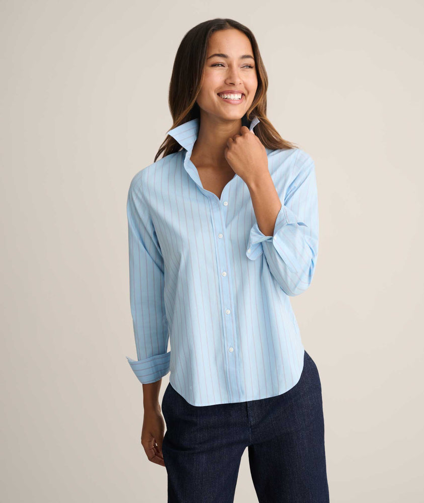 Model is wearing UNTUCKit Isabella shirt in blue and pink stripe. 