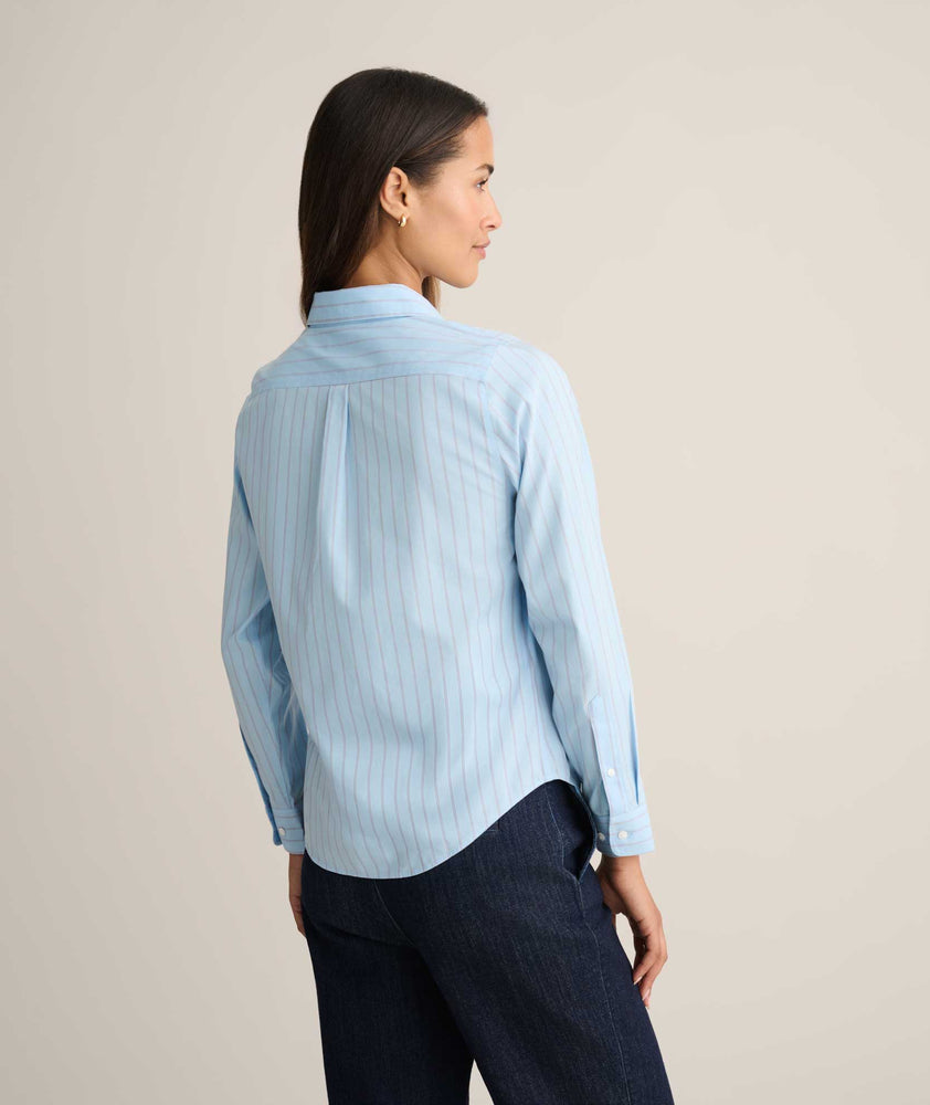 Model is wearing UNTUCKit Isabella shirt in blue and pink stripe. 