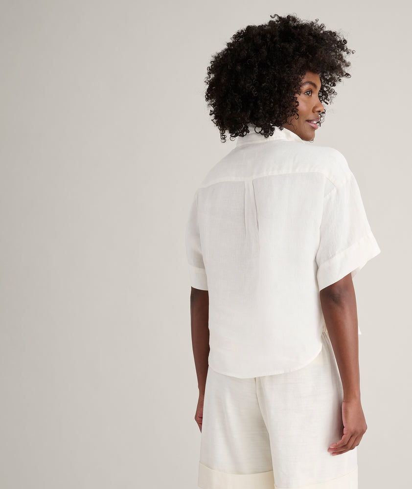 Model is wearing UNTUCKit Linen Popover Untucked Ivy Shirt in white. 