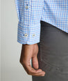 Model is wearing UNTUCKit Kaleb long sleeve performance shirt in light blue and white check. 
