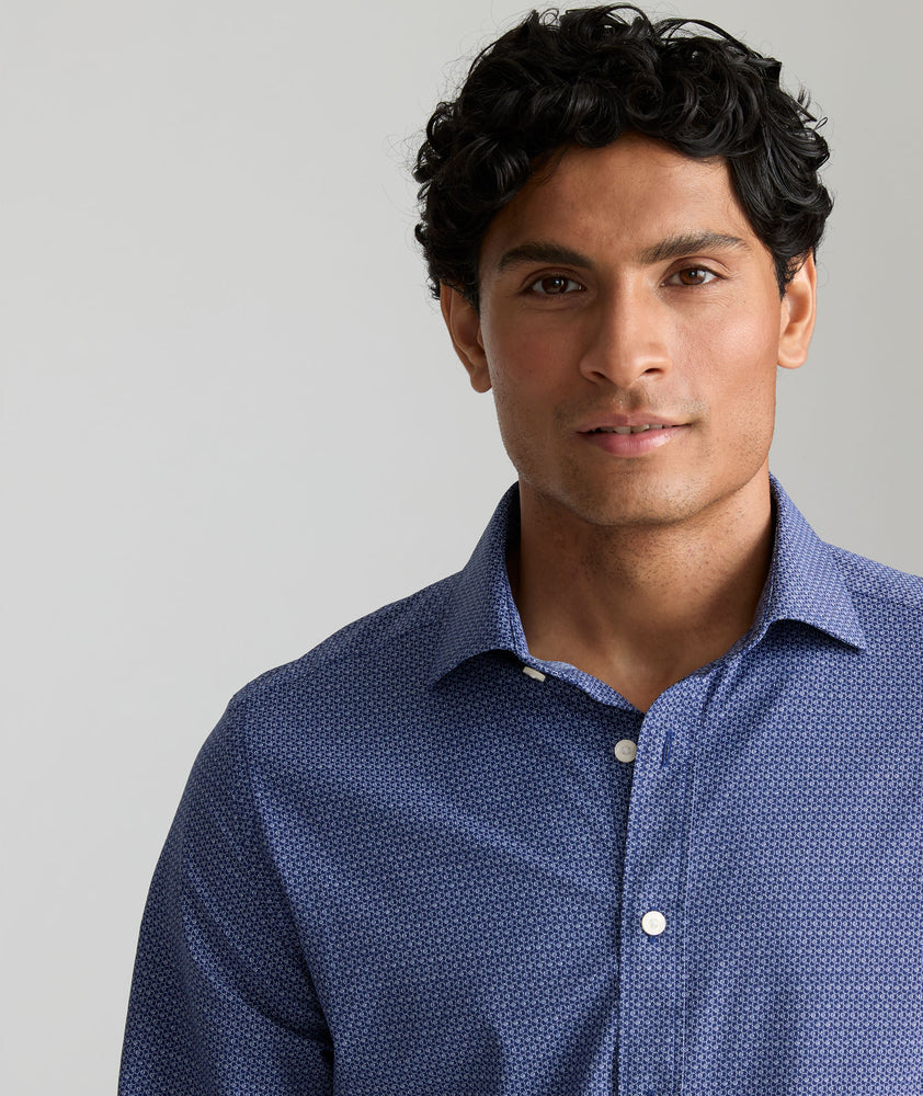 Model is wearing UNTUCKit King shirt in blue with small geo print. 