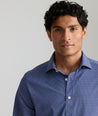 Model is wearing UNTUCKit King shirt in blue with small geo print. 