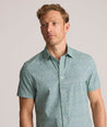 Model is wearing UNTUCKit Performance Short-Sleeve Kyros Shirt in Green Palm Print.