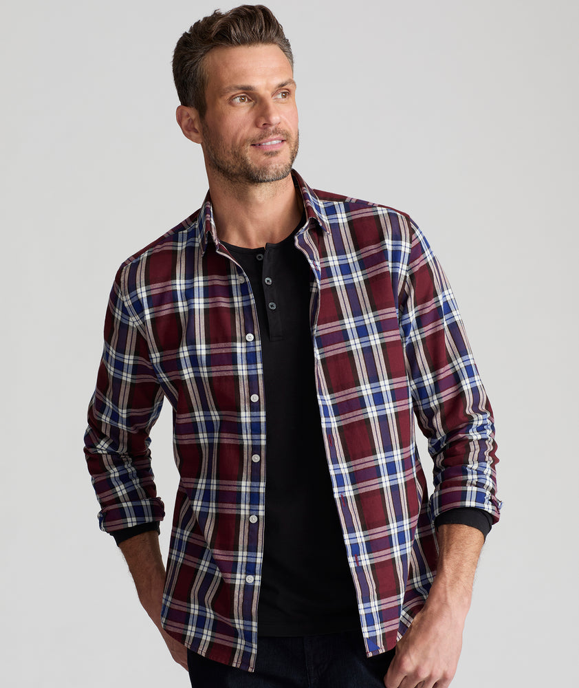 Model is wearing UNTUCKit Larson flannel in maroon grounded blue plaid. 