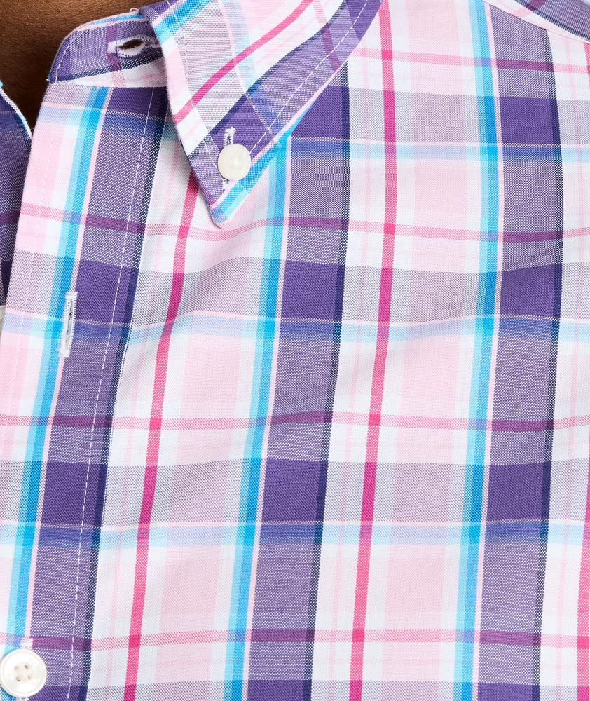 Model is wearing UNTUCKit Maitland wrinkle-free shirt in pink plaid. 