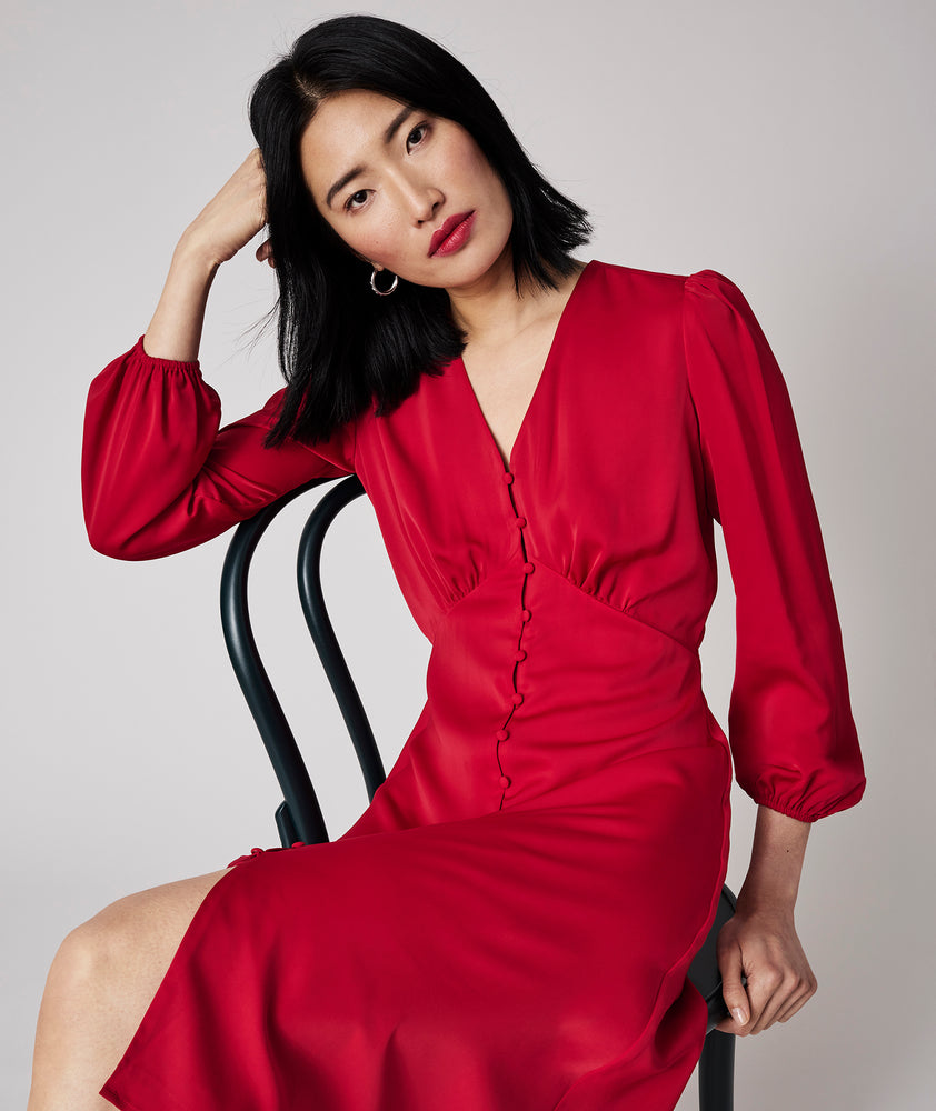 Model is wearing UNTUCKit Malory dress in red.